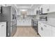 Modern kitchen features stainless steel appliances, white cabinets, and gray subway tile backsplash for a clean and contemporary design at 5300 Lido St, Orlando, FL 32807