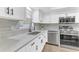 Well-lit kitchen with stainless steel appliances, gray backsplash, and white countertops and cabinets for a modern, clean design at 5300 Lido St, Orlando, FL 32807