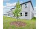 Landscaped backyard with a young tree, lawn and a covered patio, offering a serene outdoor space at 5680 Brosnan Rd, St Cloud, FL 34771
