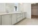 Bathroom with double sinks, white cabinets, and tiled floors at 5680 Brosnan Rd, St Cloud, FL 34771