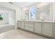 Bathroom featuring dual sinks, white cabinets, tiled floors, and a window at 5680 Brosnan Rd, St Cloud, FL 34771