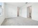 A cozy carpeted bedroom with closet and bathroom entrance; all painted a bright white at 5680 Brosnan Rd, St Cloud, FL 34771