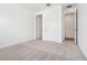 A comfortable bedroom featuring neutral carpet, base trim, and a door to the walk-in closet at 5680 Brosnan Rd, St Cloud, FL 34771