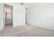 A comfortable bedroom featuring neutral carpet, base trim, and a door to the bathroom at 5680 Brosnan Rd, St Cloud, FL 34771