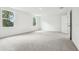 A bright bedroom featuring neutral carpet, two windows, and base trim at 5680 Brosnan Rd, St Cloud, FL 34771