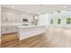 Spacious kitchen with island, white cabinets, stainless appliances and wood-look flooring at 5680 Brosnan Rd, St Cloud, FL 34771