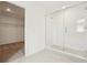 Bright bathroom showcasing an enclosed glass shower and entrance to walk-in closet at 5680 Brosnan Rd, St Cloud, FL 34771