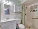 Bright bathroom featuring a white vanity, toilet, and a tiled shower with a built-in bench and recessed shelf at 599 Alton Rd, Winter Springs, FL 32708