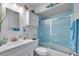 Bathroom featuring a single sink vanity and a tub shower with glass doors and blue tiled walls at 599 Alton Rd, Winter Springs, FL 32708