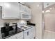 White kitchen with black countertops and stainless steel appliances at 8024 Lesia Cir, Orlando, FL 32835