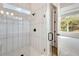 Modern bathroom with glass shower, pebble floor, and white tile at 1062 Liliana Dr, Deland, FL 32724