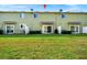 View of the back of the townhome with a large grassy area at 1927 Chatham Place Dr, Orlando, FL 32824