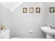 Clean and simple half bathroom with white pedestal sink and decorative framed art at 1927 Chatham Place Dr, Orlando, FL 32824