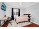 Well-lit bedroom featuring a bed, desk, and hardwood floors at 1927 Chatham Place Dr, Orlando, FL 32824