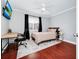 Bright bedroom with a comfortable bed, a workspace, and hardwood floors at 1927 Chatham Place Dr, Orlando, FL 32824