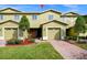 Front view of a light green two-story townhome with a brick walkway at 1927 Chatham Place Dr, Orlando, FL 32824