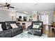 Spacious living room features leather reclining furniture and hardwood floors, open to kitchen at 1927 Chatham Place Dr, Orlando, FL 32824