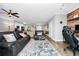 Open living room with leather furniture, hardwood floors, and a kitchen with granite countertops at 1927 Chatham Place Dr, Orlando, FL 32824