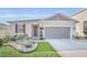 One-story house with red shutters, a two-car garage, and well-manicured landscaping at 283 Archer Way, Haines City, FL 33844