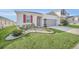 Curb appeal of a one-story home with red shutters and a two-car garage at 283 Archer Way, Haines City, FL 33844