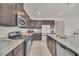 Modern kitchen with dark cabinetry, granite countertops, and stainless steel appliances at 283 Archer Way, Haines City, FL 33844