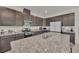 Modern kitchen with dark cabinetry, granite countertops, and island seating at 283 Archer Way, Haines City, FL 33844