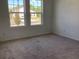 Bright bedroom featuring large windows offering scenic views and comfortable carpeting at 329 Conway Ave, St Cloud, FL 34771