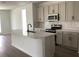 Bright kitchen features a large island, stainless steel appliances, and modern cabinets at 329 Conway Ave, St Cloud, FL 34771