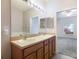 Double vanity bathroom with light wood cabinets and a view of another bedroom at 4052 Falling Lilly Ct, Winter Springs, FL 32708