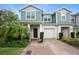 Two-story townhome with gray siding, brick driveway, and landscaping at 4052 Falling Lilly Ct, Winter Springs, FL 32708