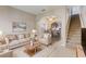 Open living room with beige sofas, a view of the kitchen and staircase at 4052 Falling Lilly Ct, Winter Springs, FL 32708
