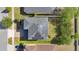 Aerial view of a home featuring solar panels on the roof and a well-maintained lawn at 445 Kestrel Dr, Groveland, FL 34736