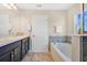 Bright bathroom featuring a soaking tub, double sink vanity, and neutral color palette at 445 Kestrel Dr, Groveland, FL 34736