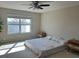 Spacious bedroom featuring a ceiling fan, natural light, and neutral paint tones at 445 Kestrel Dr, Groveland, FL 34736