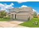 Traditional two-story home with a spacious driveway, lush lawn, and mature landscaping at 445 Kestrel Dr, Groveland, FL 34736