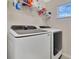 Modern laundry room with a front-load washer and dryer set and storage shelves at 445 Kestrel Dr, Groveland, FL 34736