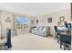 Spacious living room featuring a large window, comfortable seating, and work-from-home space at 445 Kestrel Dr, Groveland, FL 34736