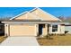 Tan two-story house with a two-car garage and landscaped yard at 4450 Sagefield Dr, Harmony, FL 34773
