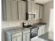 Gray cabinets, granite countertops and stainless steel appliances in a modern kitchen at 4450 Sagefield Dr, Harmony, FL 34773