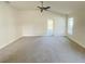 Spacious living room with carpeted floor, ceiling fan and door leading to backyard at 4450 Sagefield Dr, Harmony, FL 34773