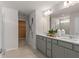 Double vanity bathroom with gray cabinets and an adjacent closet at 5026 Starling Bird Ln, St Cloud, FL 34771