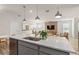 Kitchen island with seating, modern fixtures, and a view of the living room at 5026 Starling Bird Ln, St Cloud, FL 34771