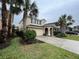 Two-story house with tan exterior, arched entryway, and palm trees at 5298 Wildwood Way, Davenport, FL 33837