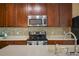 Stainless steel appliances and rich wood cabinets in kitchen at 6002 Tivoli Gardens Blvd, Orlando, FL 32829