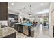 This kitchen boasts an island, stainless steel appliances, granite countertops, dark cabinets, and an open floorplan at 782 Grand Hilltop Dr, Apopka, FL 32703