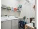 A laundry room equipped with a washer, dryer, sink, shelving and cleaning supplies at 782 Grand Hilltop Dr, Apopka, FL 32703