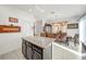 Granite kitchen island with seating overlooking dining area at 1008 E 10Th St, Apopka, FL 32703