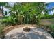 Landscaped backyard with a fire pit and a stone retaining wall at 13005 Islamorada Dr, Orlando, FL 32837