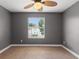 Gray bedroom with ceiling fan and large window at 13005 Islamorada Dr, Orlando, FL 32837