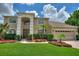Two-story house with a three-car garage and manicured lawn at 13005 Islamorada Dr, Orlando, FL 32837